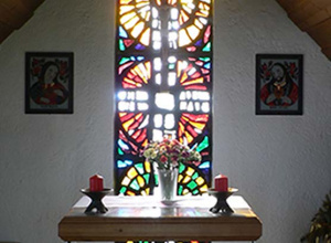 Image of a stained glass window behind a communion table.